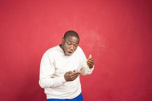 Portrait of a joyful young man holding mobile phone photo