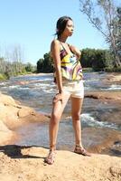 Young black woman in shorts by the river photo