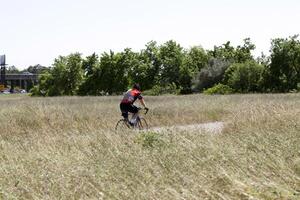 Folsom, CA, 2011 - Lone male biker amid field of grass photo