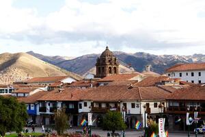 cusco, Perú, 2015 - Iglesia campana torre con rodeando rojo loseta techos colinas cielo foto