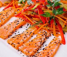 Salmon Slices with Carrot and Pepper Salad and Soy Sauce - Asian Cuisine photo