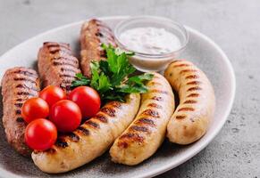fried sausages with tomatoes cherry on plate photo