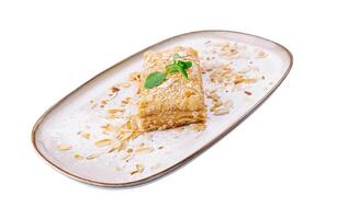 Napoleon Cake with almond on a white plate photo