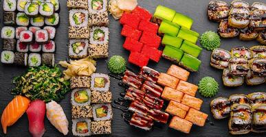 Large sushi set, shot from the top on a black background photo