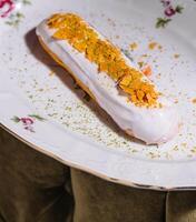 Close up of eclair with white cream and chips photo