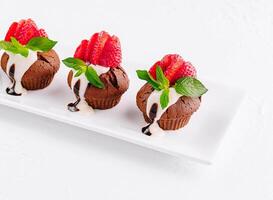 Cupcakes with strawberries on white plate photo