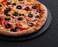 Pizza with tomato, olives, champignons, ham and cheese photo