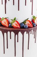 blanco pastel con Derretido oscuro chocolate con Fresco bayas foto