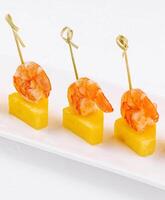 Canapes with shrimp and pineapple on plate photo