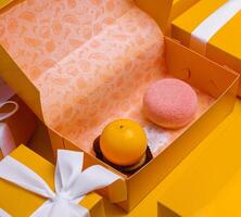 Christmas gifts presents with different cakes on yellow background photo