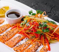 Salmon Slices with Carrot and Pepper Salad and Soy Sauce - Asian Cuisine photo