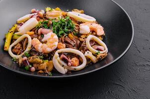 Buckwheat noodles with seafood in black plate photo