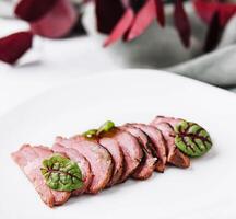 Sliced duck breast roasted meat on a plate photo