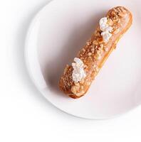 eclair con caramelo y nueces en blanco plato foto