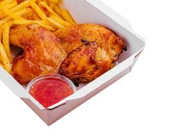 Fried chicken legs with french fries in paper box photo