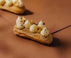 eclairs with whipped cream and hazelnuts photo