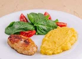 polenta with cutlet and cherry tomatoes with basil photo