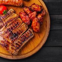 pork ribs with chicken and sausages on wooden board photo