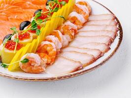 salmon, white fish, shrimp and red caviar on plate photo