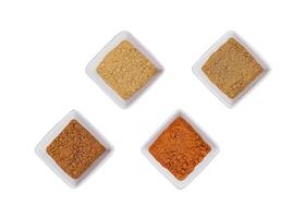 Various Indian Spices in Small White Bowls on white background photo