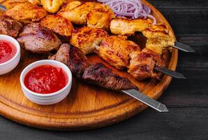 Metal skewers with delicious meat and ketchup sauce photo