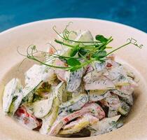 Salad with fresh vegetables and cream sause on plate photo