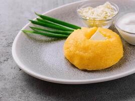 polenta con cebollas, queso feta queso y agrio crema foto