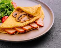 Thin delicious pancake with ham and mushrooms photo