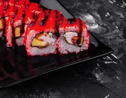 Sushi Roll California on black stone plate photo