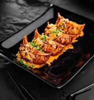 Fried dumplings Gyoza on black plate photo