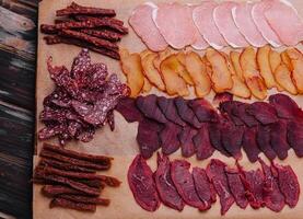 various jerky or dried meats and sausage on a board photo