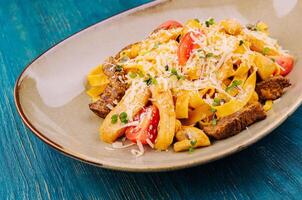 Fettuccine pasta with beef, chicken and parmesan photo