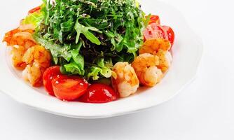 Healthy arugula salad bowl with shrimp, tomato, and sesame seeds photo