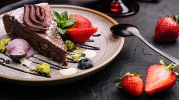 Brownie cake with a scoop of vanilla ice cream and strawberries photo