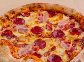pepperoni pizza with ham on wood photo