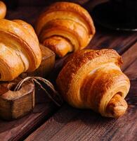 apetitoso croissants en de madera mesa de cerca foto