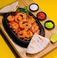 Fried large shrimp with onions and peppers in a frying pan photo