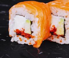 Salmon sushi with rice, avocado and red caviar photo