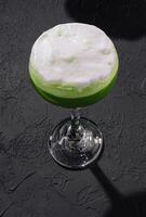 Green alcoholic cocktail for women with foam photo