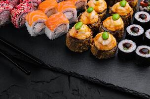 Sushi set on black slate top view photo