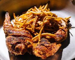 Fried chicken leg with french fries on pan photo