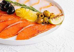 salmon, white fish and olives on plate photo