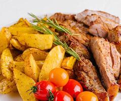 Grilled kebab pork meat with roasted potato and vegetables photo