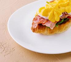 Croissant sandwich with bacon, cheese and egg photo