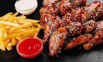 chicken wings with legs in Chinese sauce with french fries photo