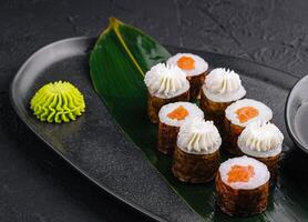 Sushi con Filadelfia queso y salmón en negro asiático plato foto