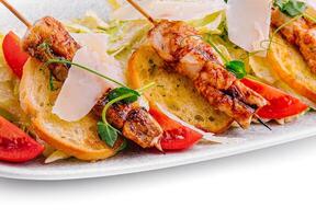 trendy Caesar salad with chicken on wooden skewers photo