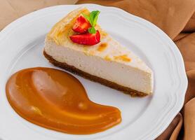 Piece of cheesecake with caramel close up photo