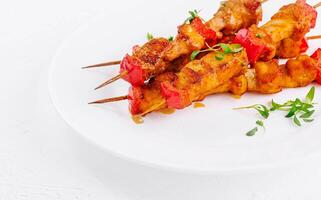 Chicken skewers with slices of sweet peppers photo