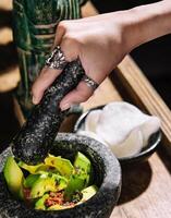 Guacamole in a mortar with rice chips photo